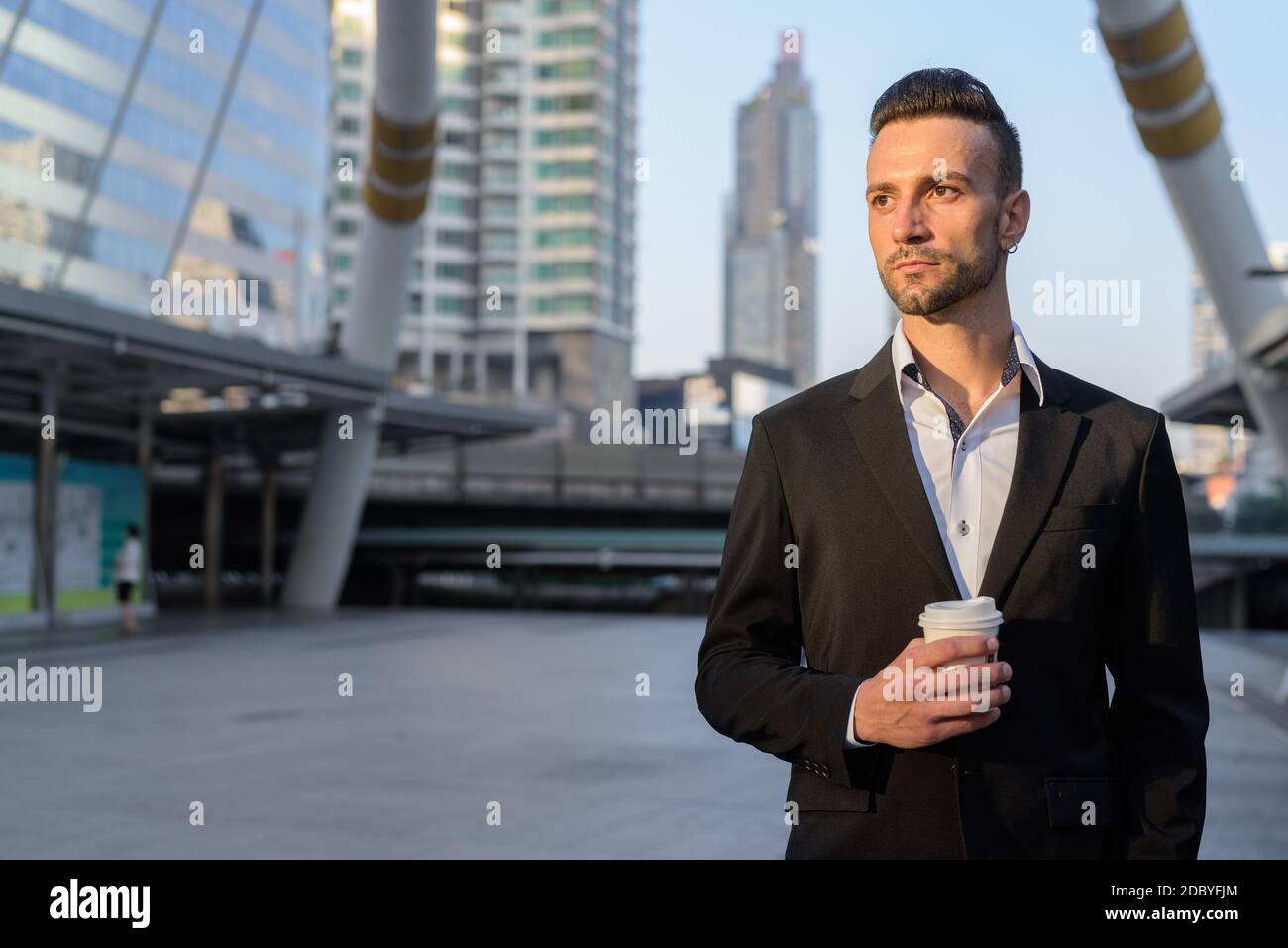 Geschäftsmann im Freien in der Stadt hält Kaffeetasse beim Denken Stockfoto