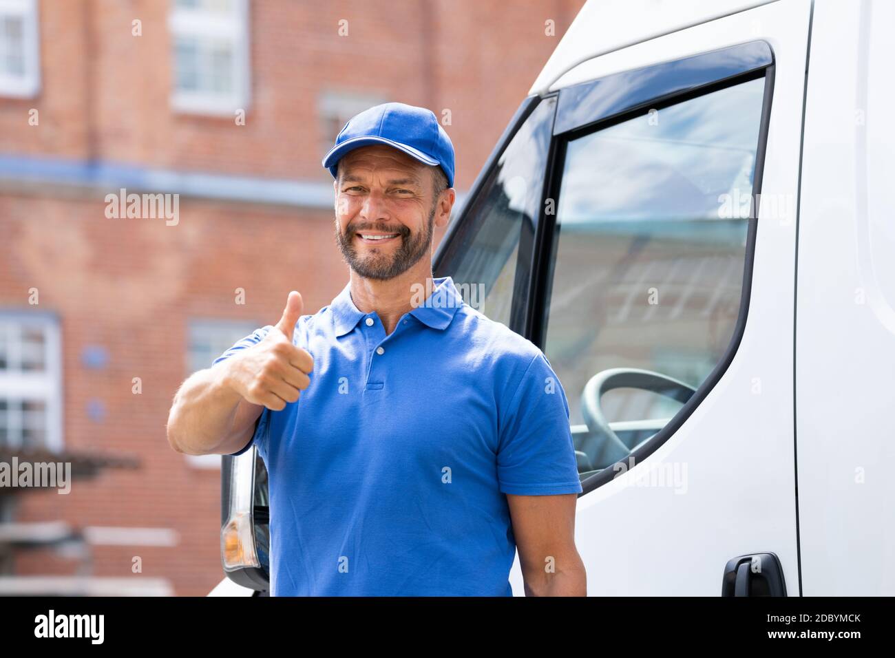 Lächelnde Lieferung Männer Oder Handyman In Uniform Nahe Lkw Stockfoto