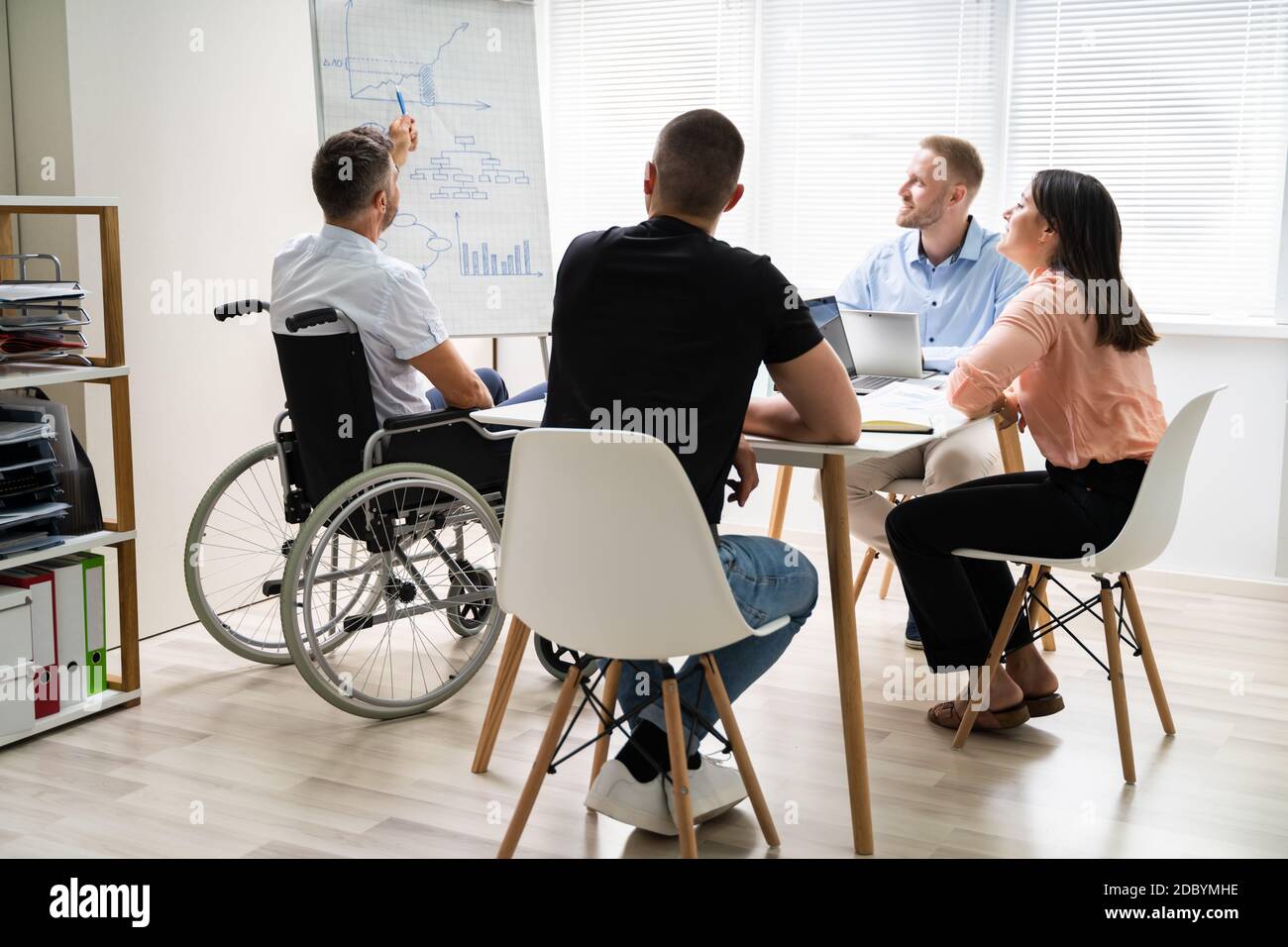 Rollstuhl Und Behinderung Im Büro. Präsentation Bei Der Arbeit  Stockfotografie - Alamy