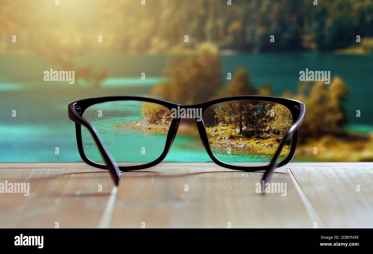 Gläser, die das Sehen von unscharf zu scharf verbessern. Holzvordergrund Stockfoto