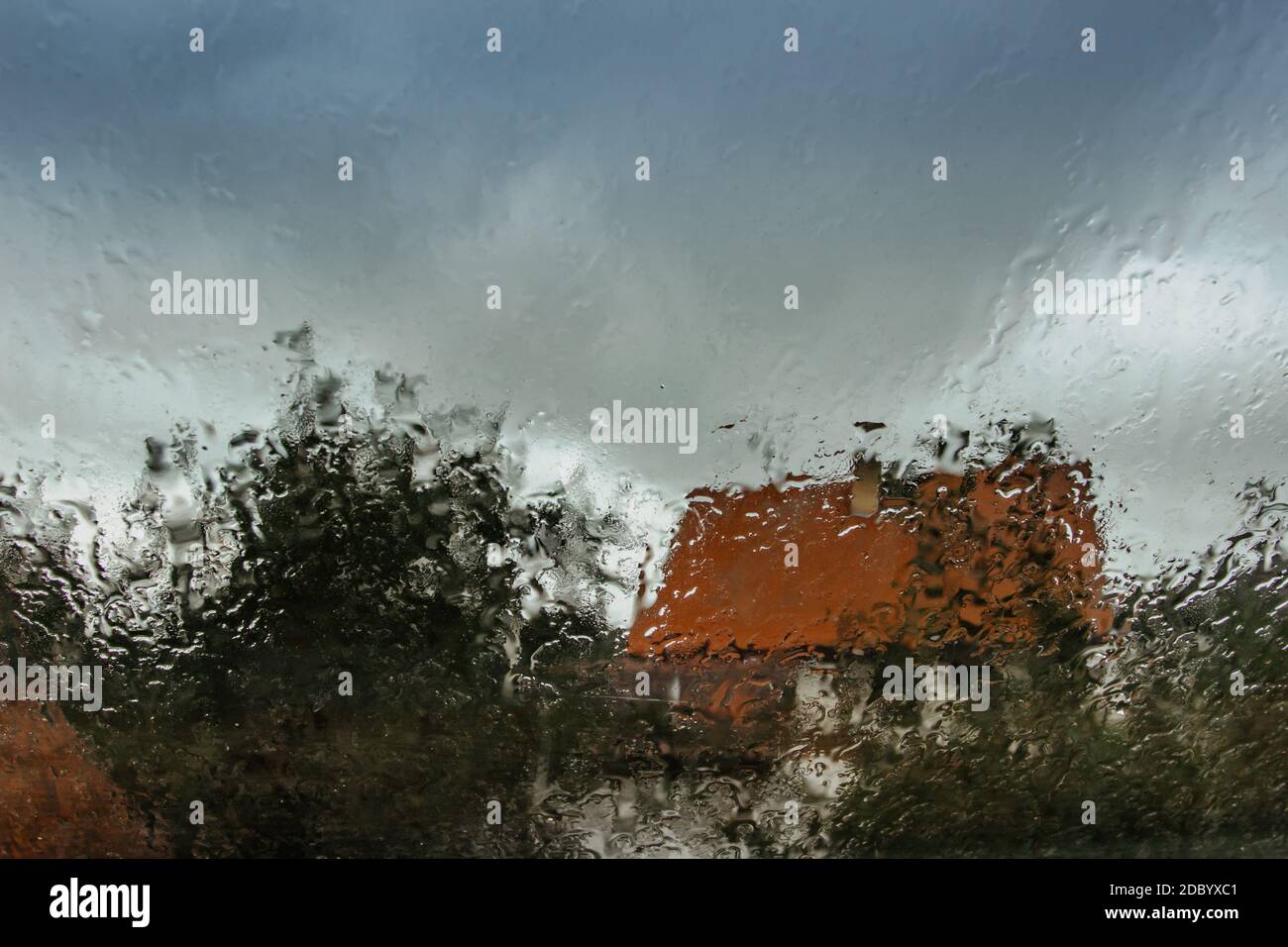 Tropfen auf Glas in regnerischen Tag.Regen Außenfenster in der Landschaft. Textur von Regentropfen, nasses Glas.regnerischer Fensterhintergrund.Blick durch das Fenster Stockfoto
