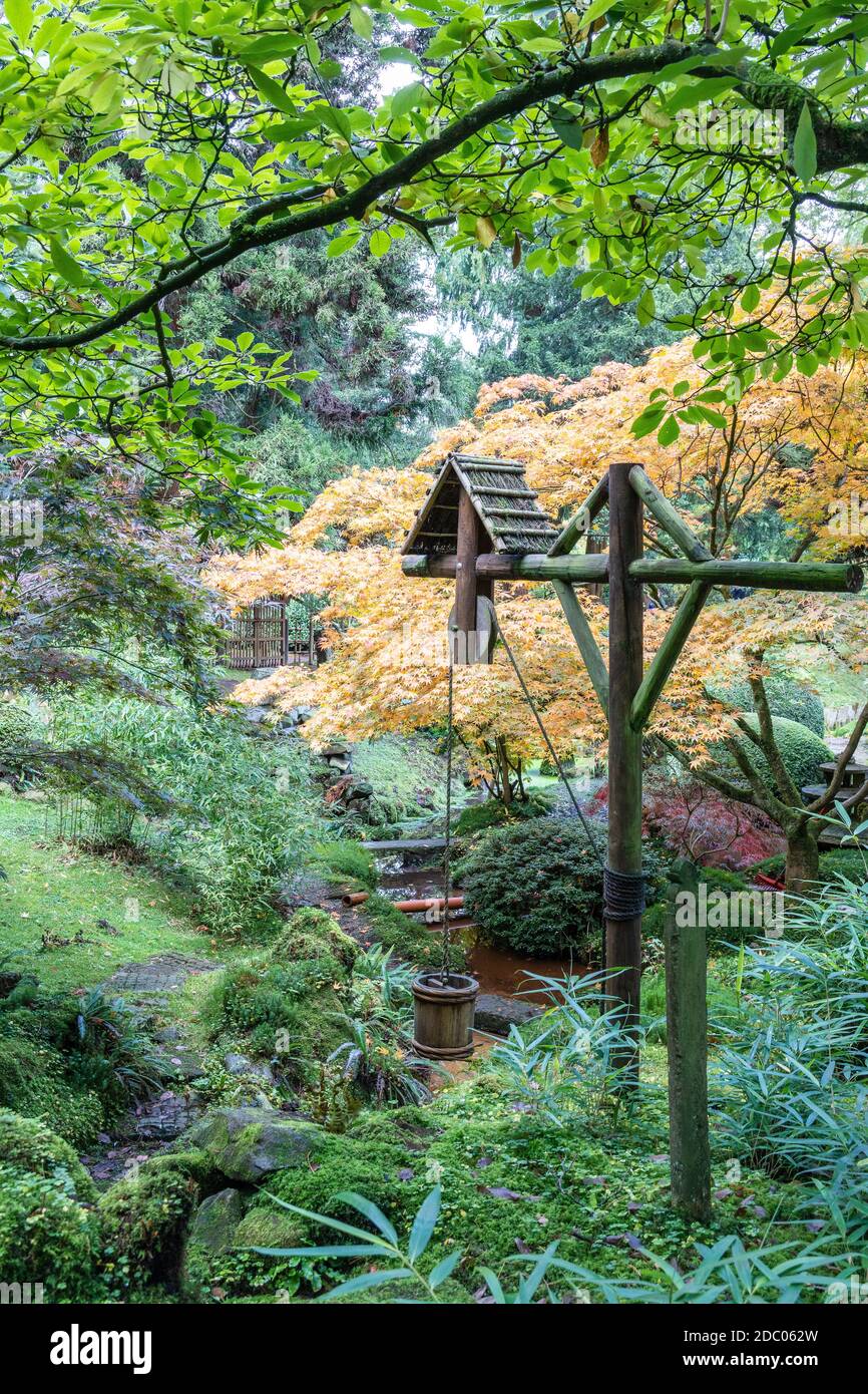 Malerische Ecke des Japanischen Gartens mit altem Holzeimer und Wasserhebel im Tatton Park, England. Stockfoto