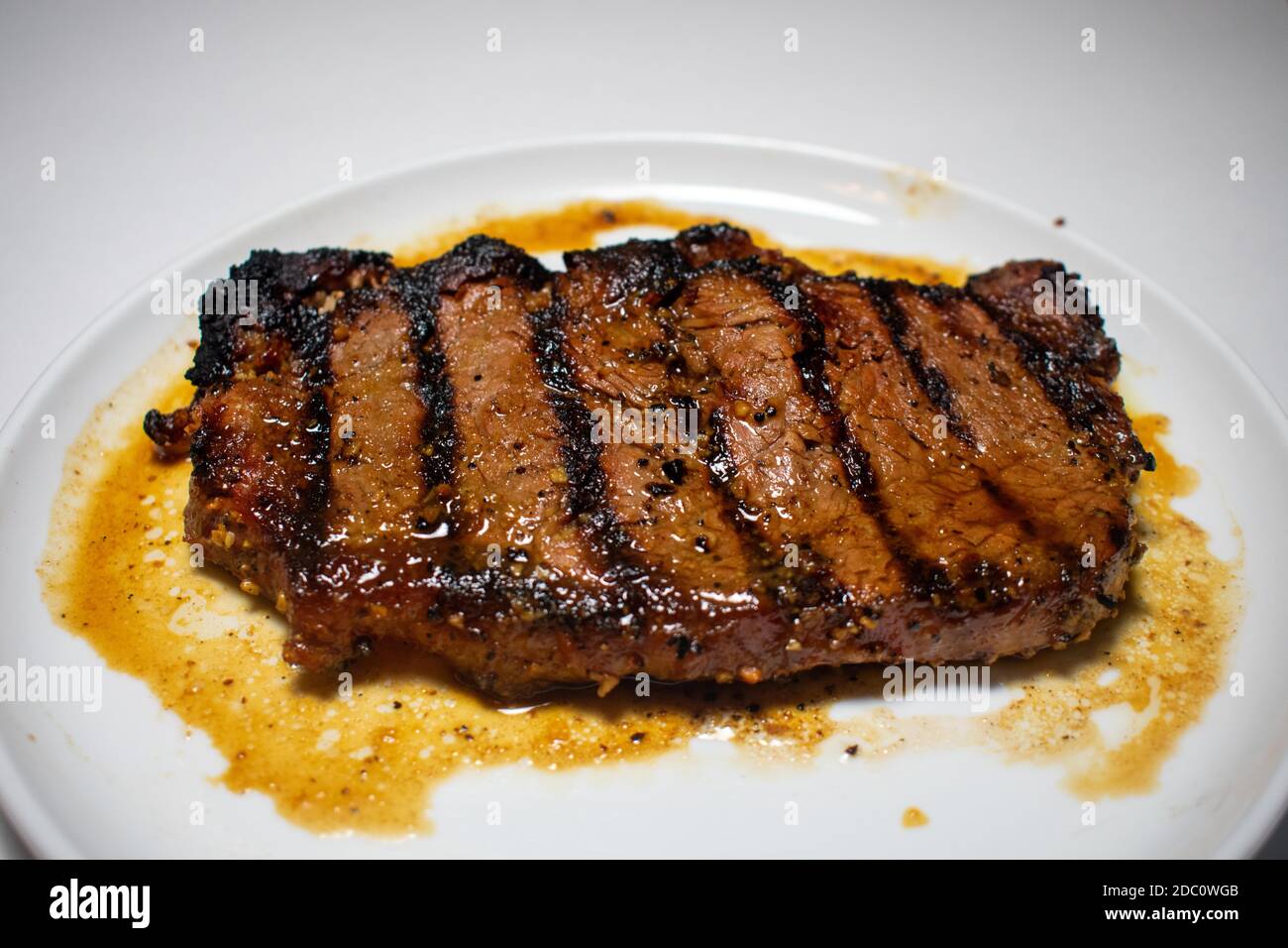 Ein perfekt gegartes Steak mit Grilllinien, die auf einem Reiner Weißer Hintergrund Stockfoto