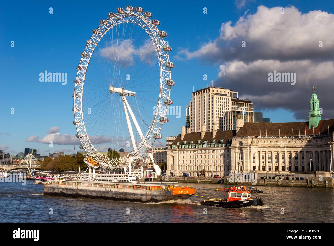 GPS Marine Schlepper GPS Cambria zieht eine Barge auf der Themse. London, Großbritannien. Flussverkehr für die Wirtschaft. London Eye und County Hall am Flussufer Stockfoto