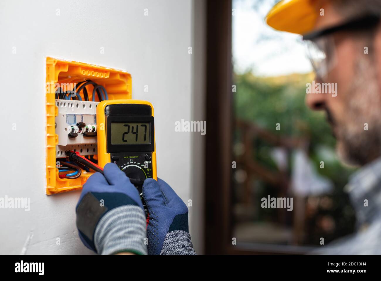 Elektriker bei der Arbeit mit dem Tester misst die Spannung in der elektrischen Zentrale einer Wohnanlage. Bauindustrie. Stockfoto