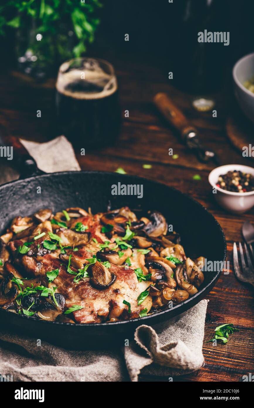 Gebratenes Schweinehals Steak mit verschiedenen Pilzen Gusseisen Pfanne ...