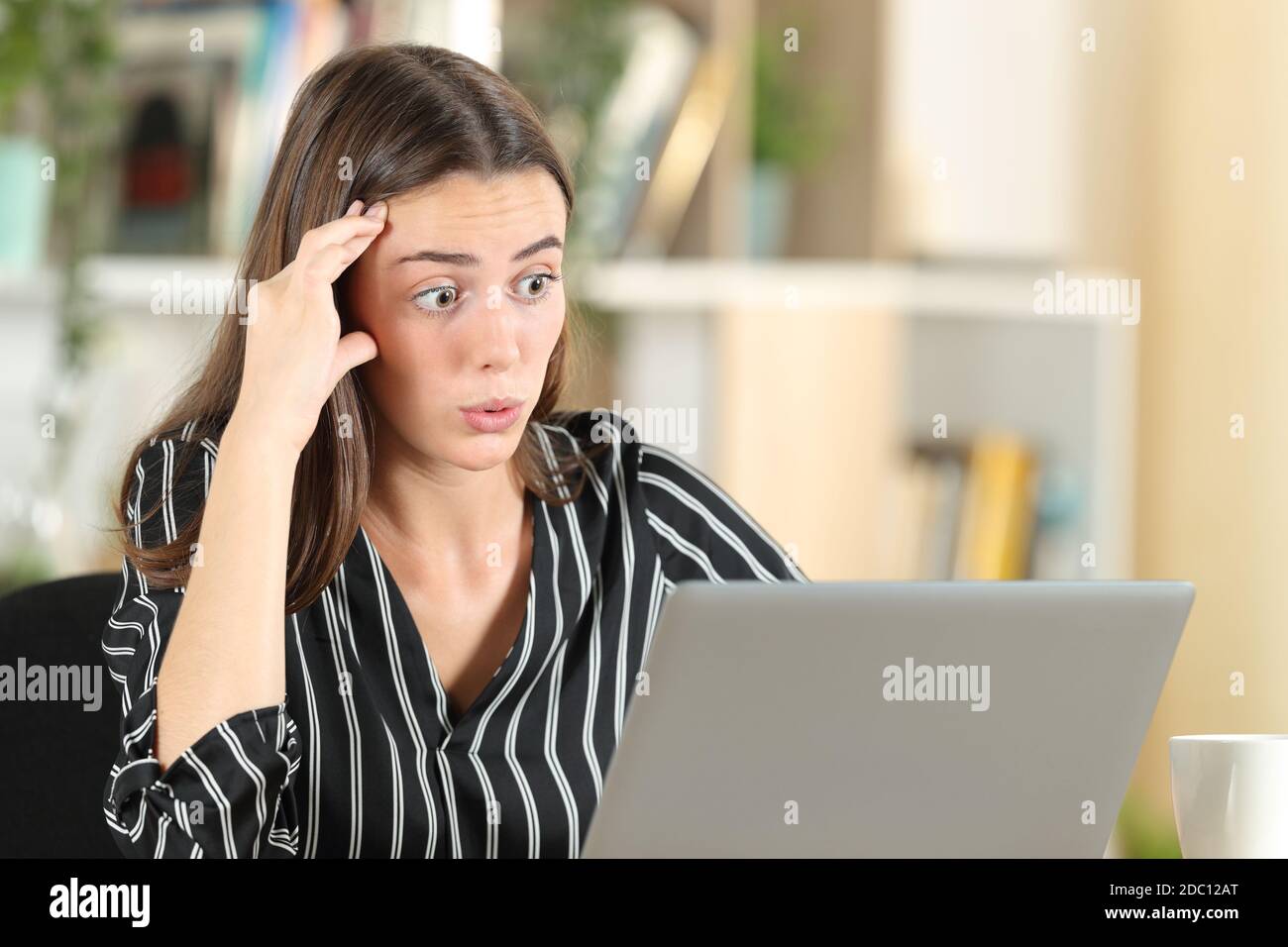 Besorgt Frau Entdeckung Fehler auf Laptop sitzen zu Hause Stockfoto