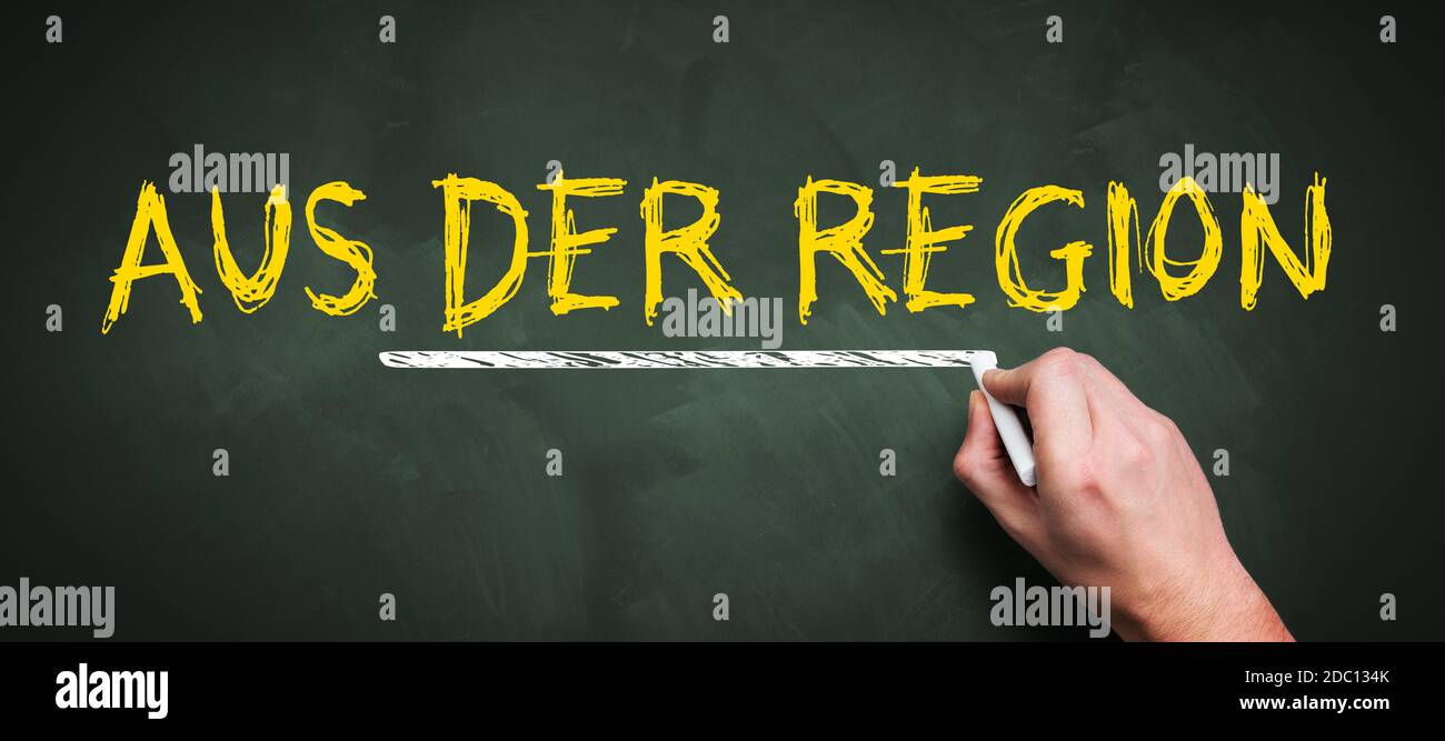 Hand schreibt deutsche Botschaft für REGIONALE PRODUKTION auf einem Tafel Stockfoto