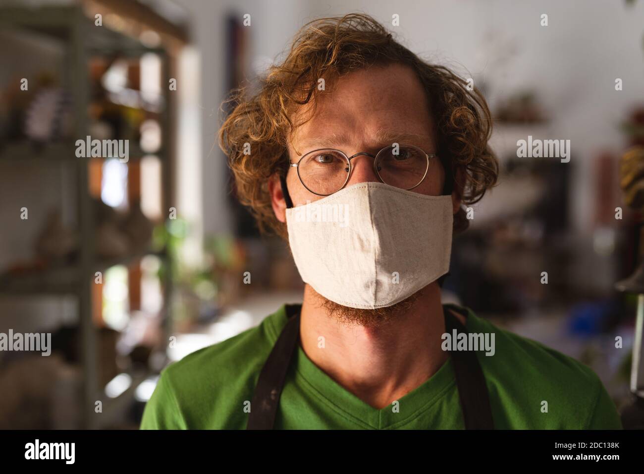 Portrait des kaukasischen Mannes mit Gesichtsmaske im Töpferstudio Stockfoto