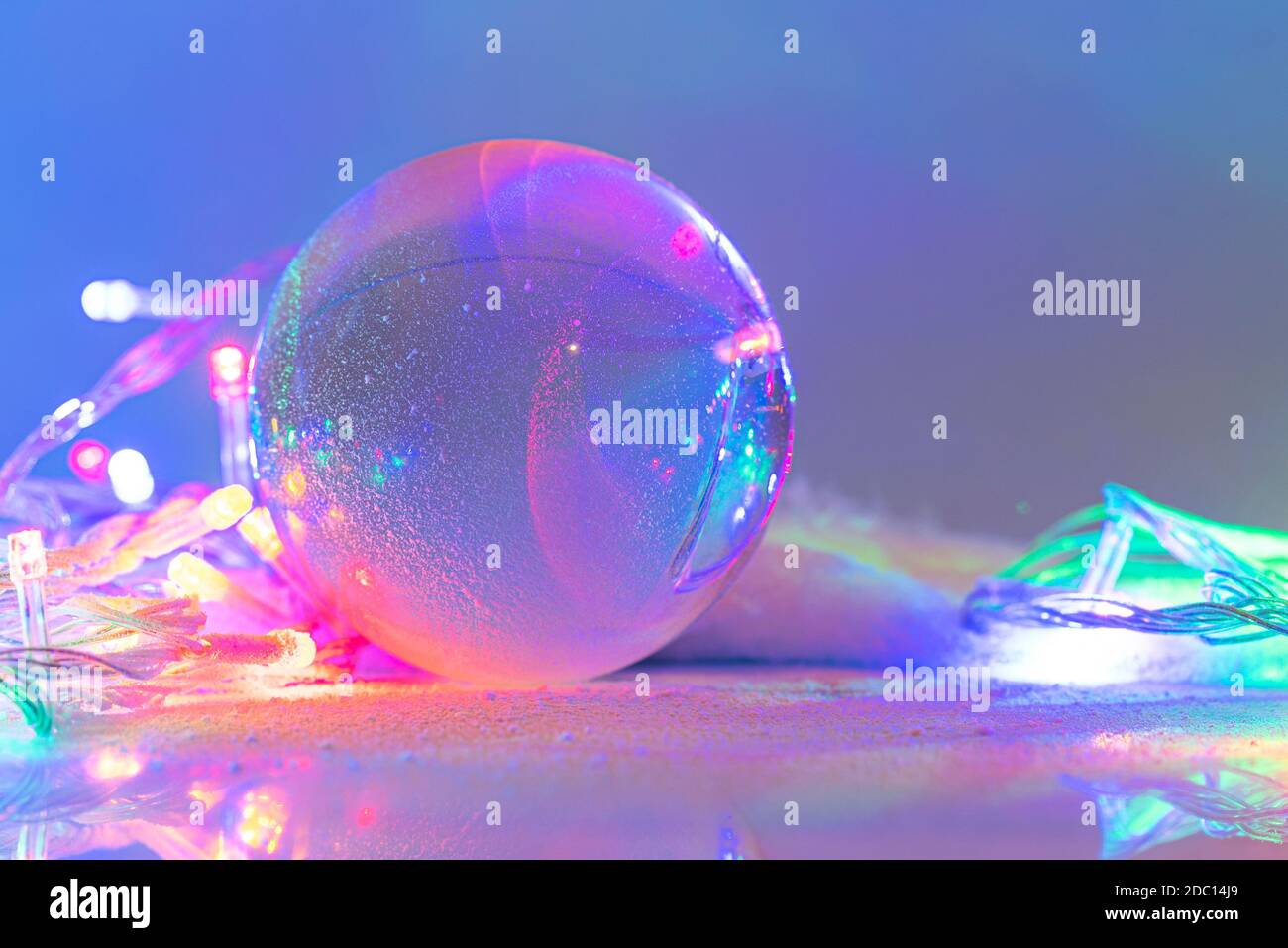Schneekugel oder Glaskugel mit Schnee bedeckt mit Girlande, Weihnachtsdekoration, Layout, Platz für Text, Postkarte. Stockfoto