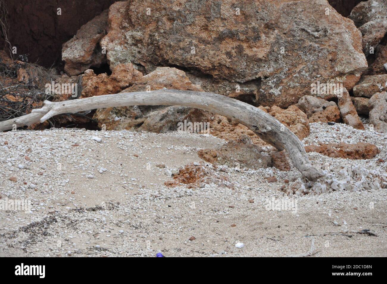 Abstrakte rote Klippe am kroatischen Strand, Holz aus der Adria. Strand Hintergrund. Abstrakt verwitterte Felsen am Sandstrand. Stockfoto