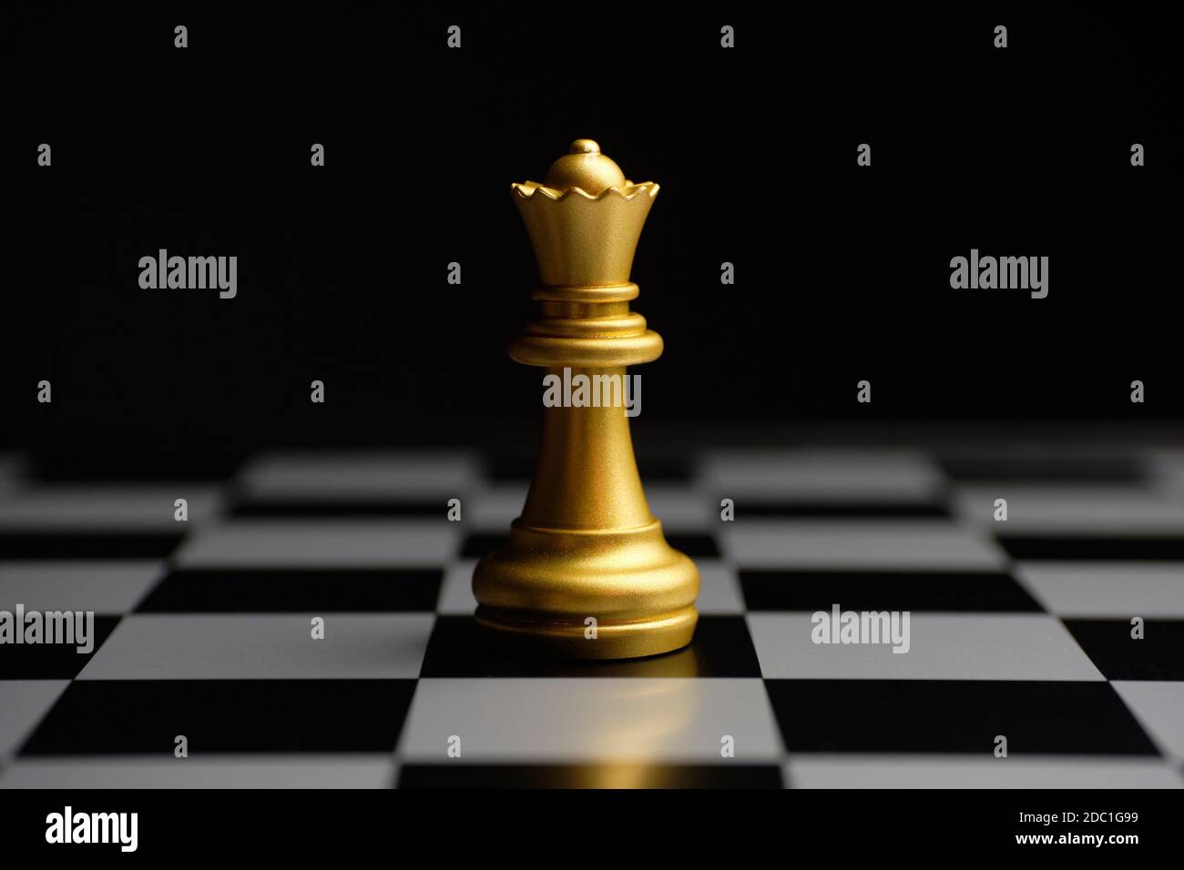 Vergoldete Schachspielkönigin auf dem Brett. Stockfoto