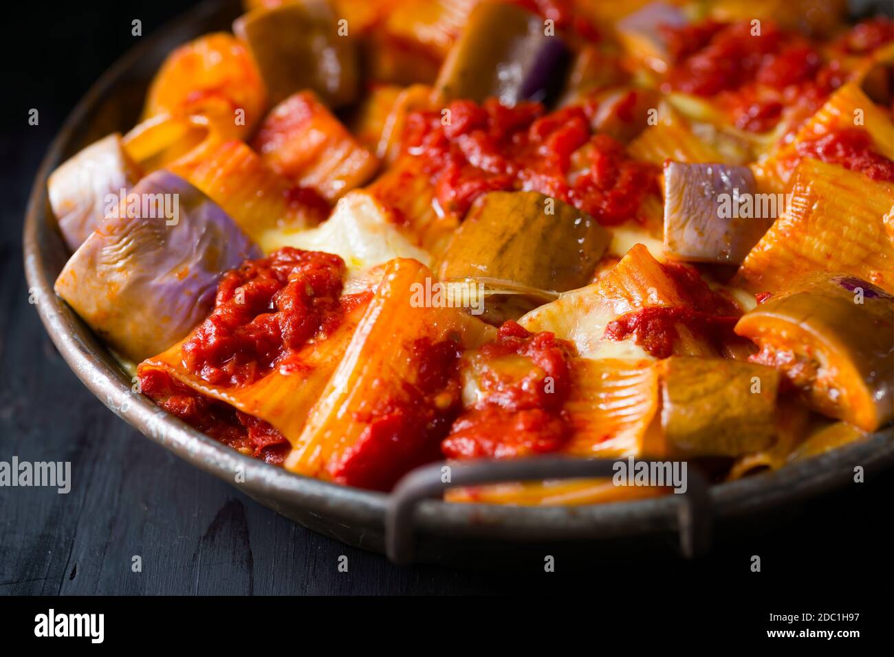 Nahaufnahme der rustikalen italienischen gebackenen Käse Rigatoni Pasta mit Auberginen und Tomatensauce Stockfoto