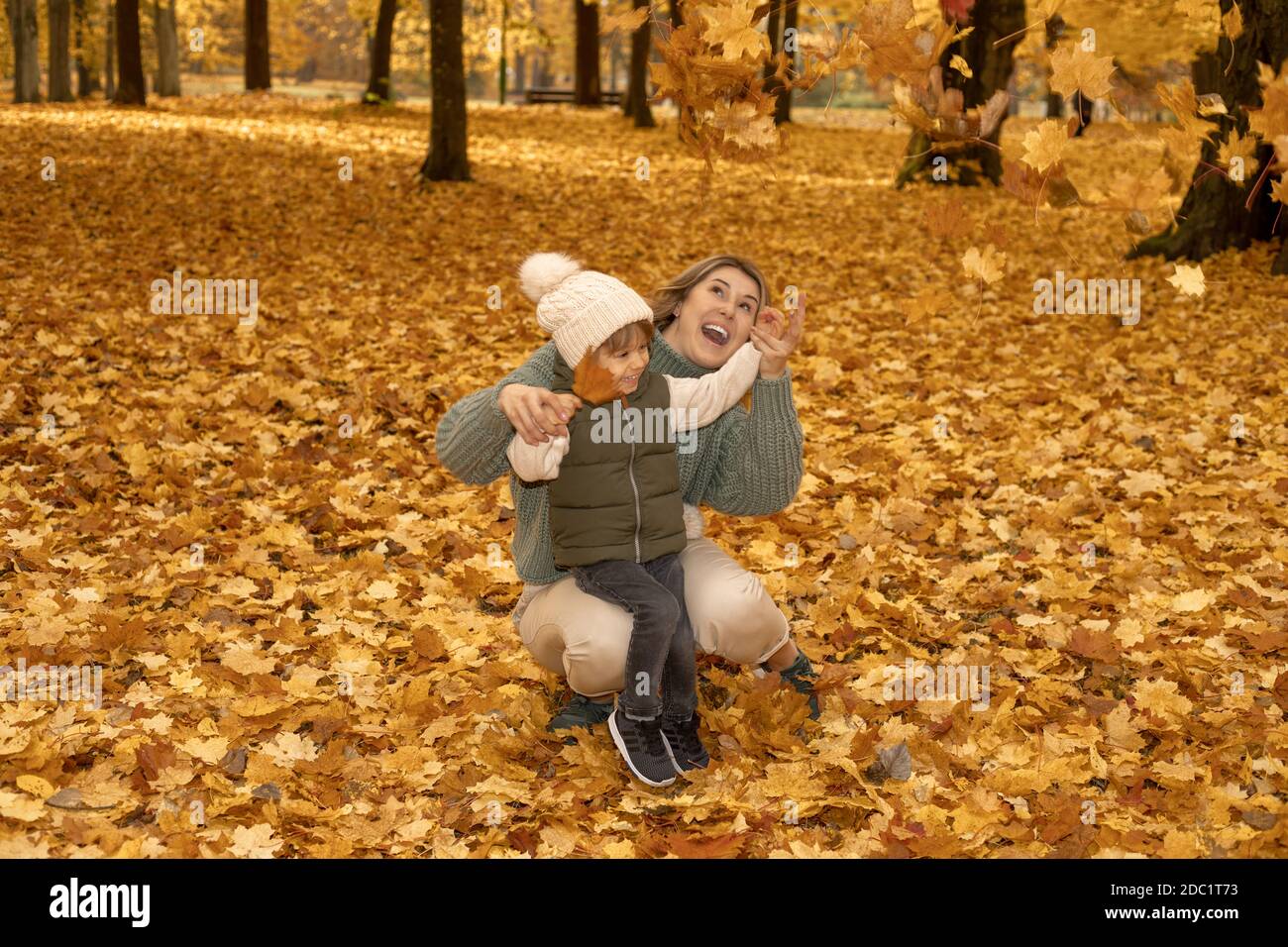 Junge Mutter mit ihrem kleinen Sohn im Herbstpark haben einen Ventilator. Gelbes Laub, Zeit im Freien mit Kindern. Unabhängig Glücklich Single Mutter Stockfoto