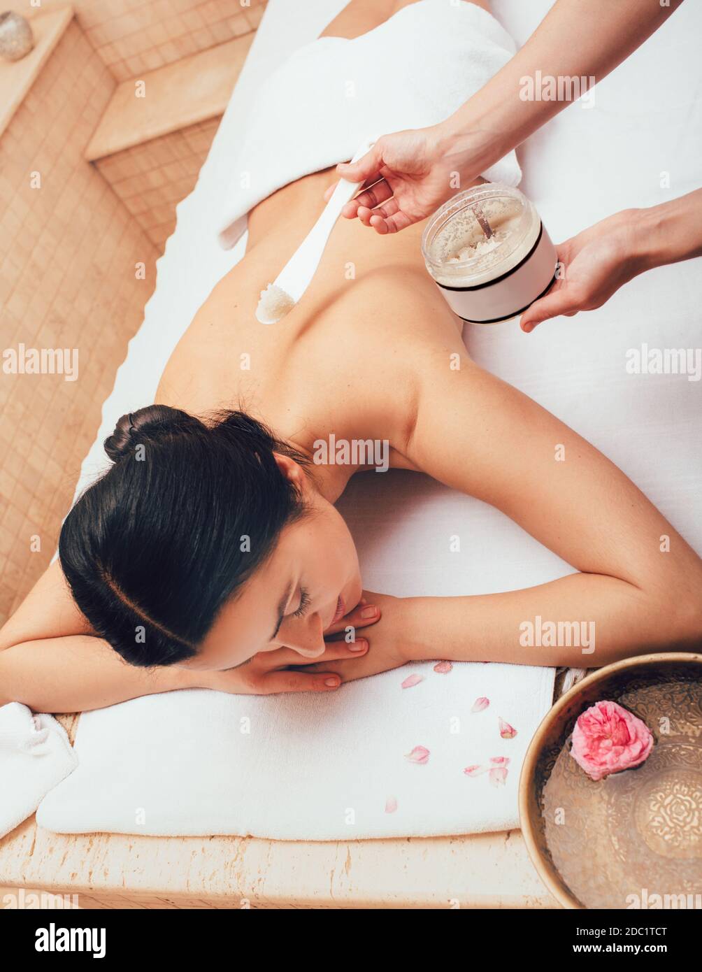 Schöne Brünette Frau während Körper Peeling im Spa. Genießt Hautpeeling, Hautreinigung und Erneuerung Stockfoto