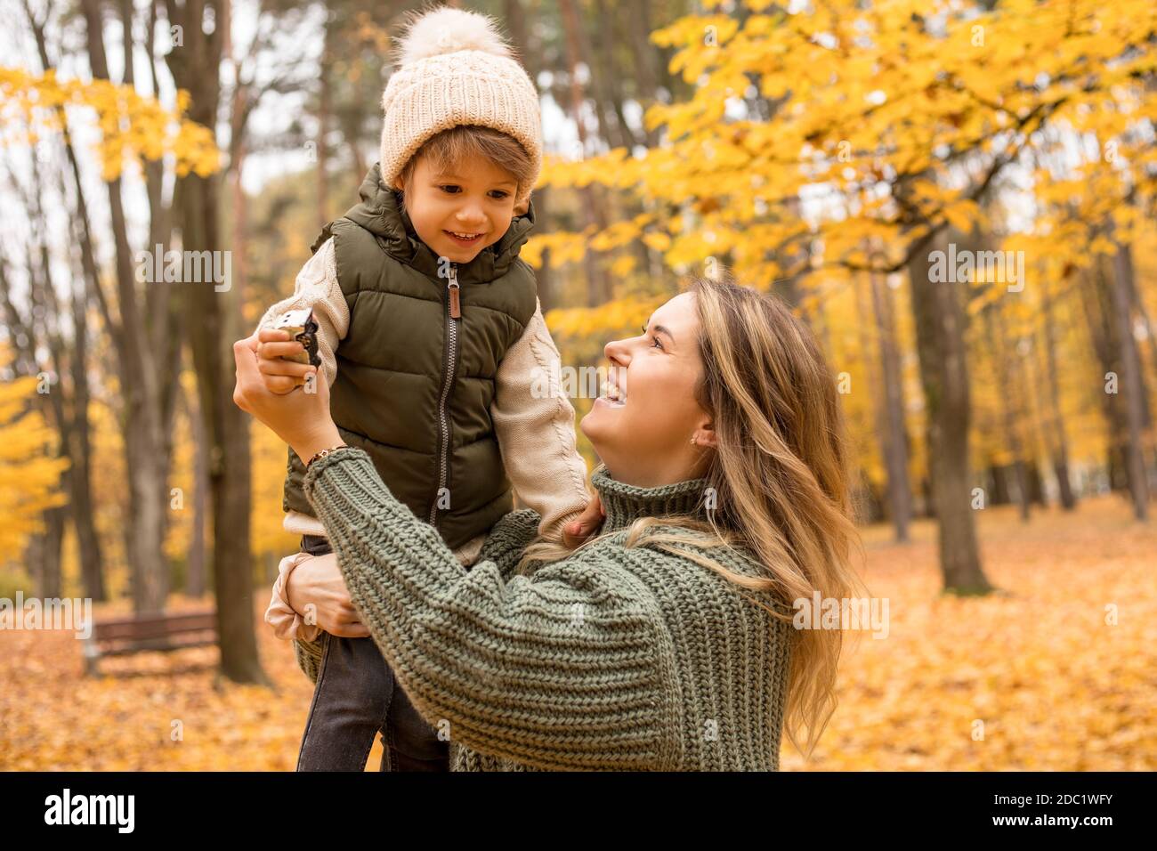 Junge Mutter mit ihrem kleinen Sohn im Herbstpark haben einen Ventilator. Gelbes Laub, Zeit im Freien mit Kindern. Unabhängig Glücklich Single Mutter Stockfoto