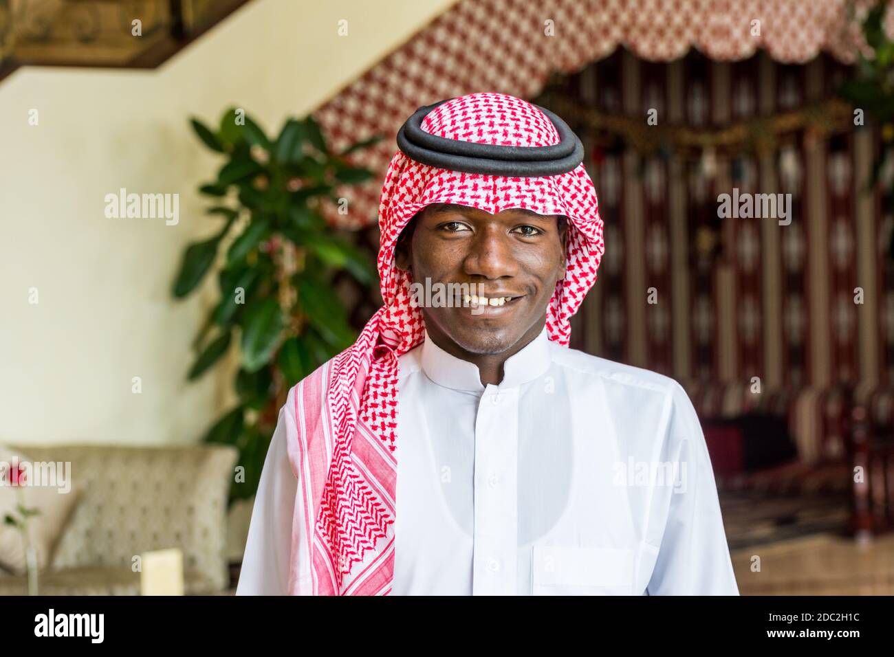 Ein Saudi-arabischer Kellner in traditioneller arabischer Kleidung mit Hintergrund eines Luxushotels in Dammam City, Königreich Saudi-Arabien Stockfoto