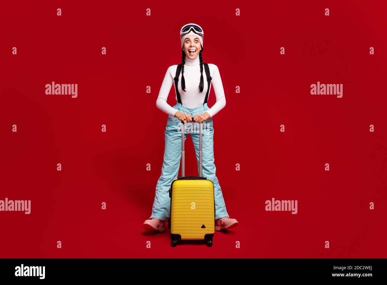 Foto in voller Größe von jungen glücklich aufgeregt verrückte Mädchen mit  Schwänze tragen blaue Hosen halten Gepäck isoliert auf rote Farbe  Hintergrund Stockfotografie - Alamy