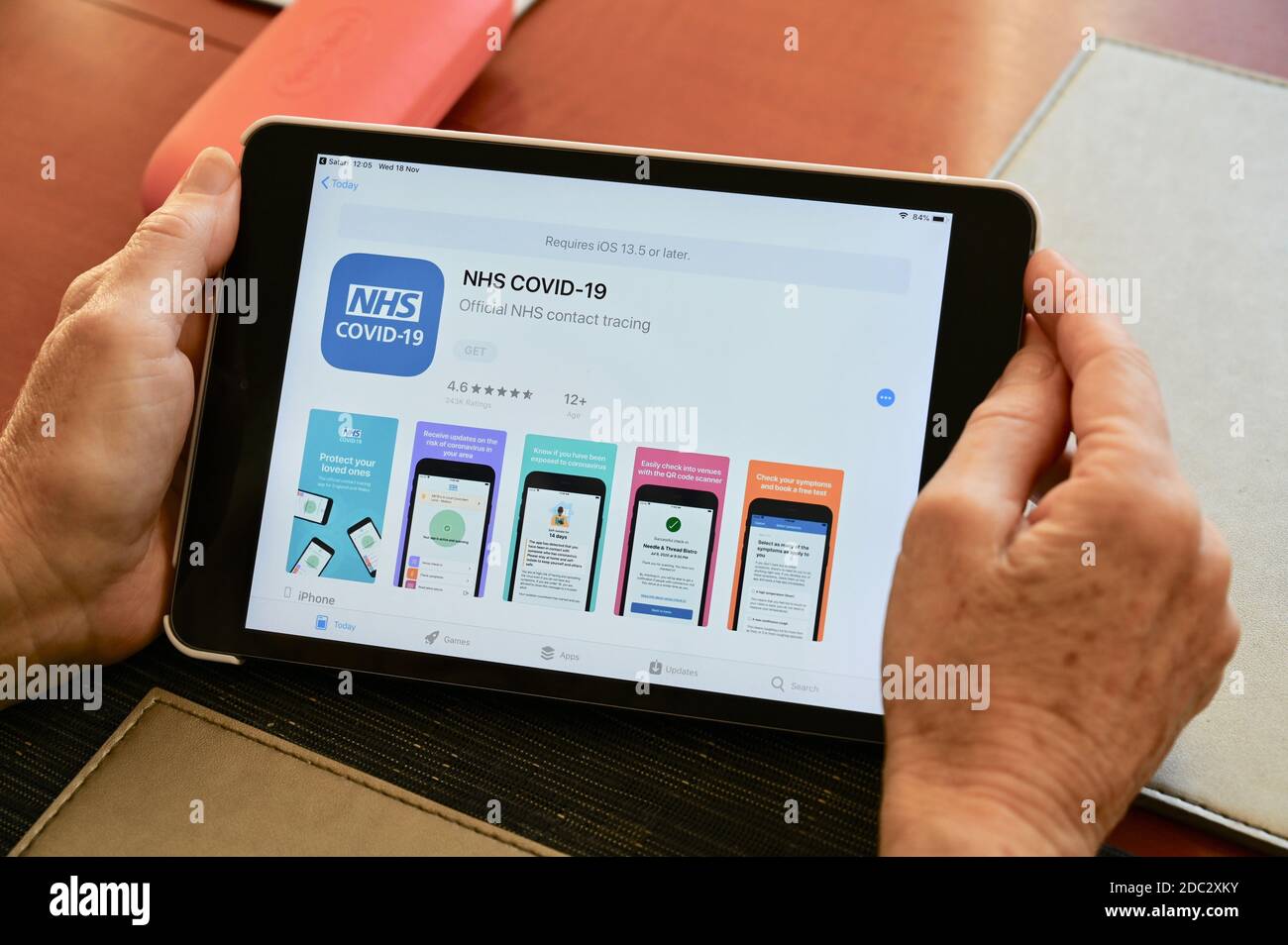 Nahaufnahme einer älteren Frau, die die NHS COVID-19 Contact Tracing App auf ihrem Apple iPad betrachtet. Stockfoto