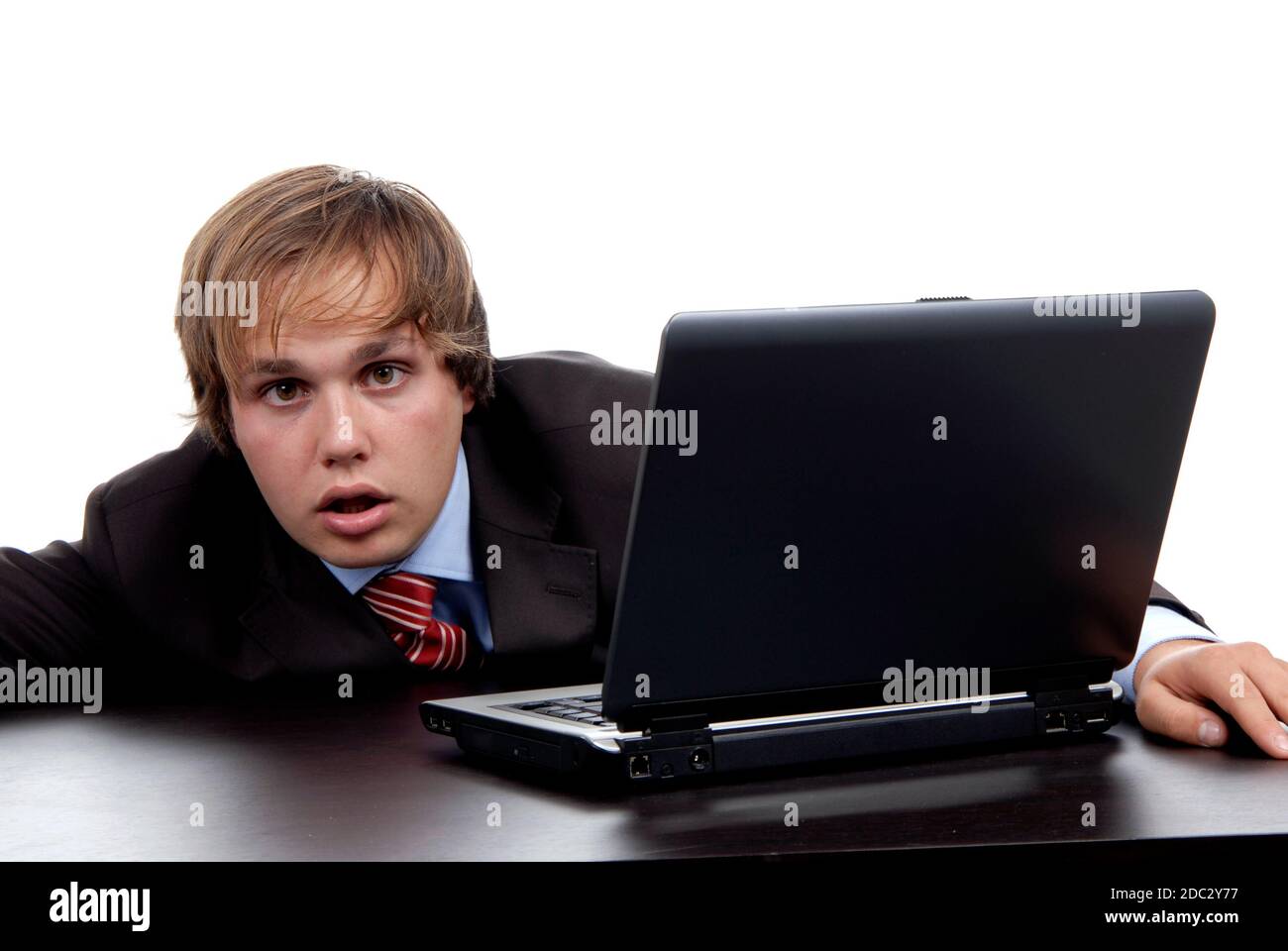 Junger dummer Mann, der mit seinem PC arbeitet Stockfoto