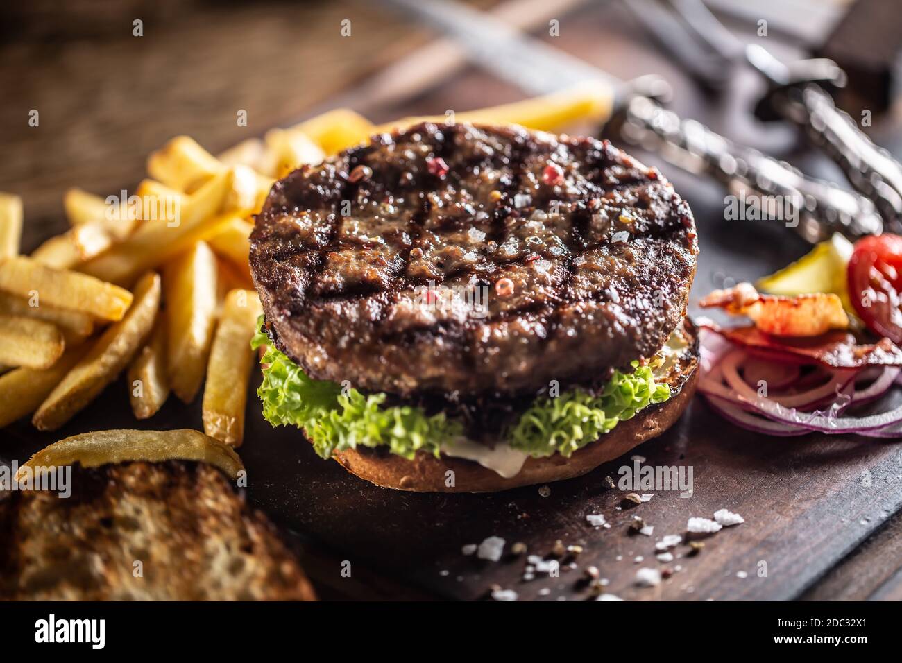 Klassischer Rindfleischburger mit Salatzwiebel und pommes frites Stockfoto