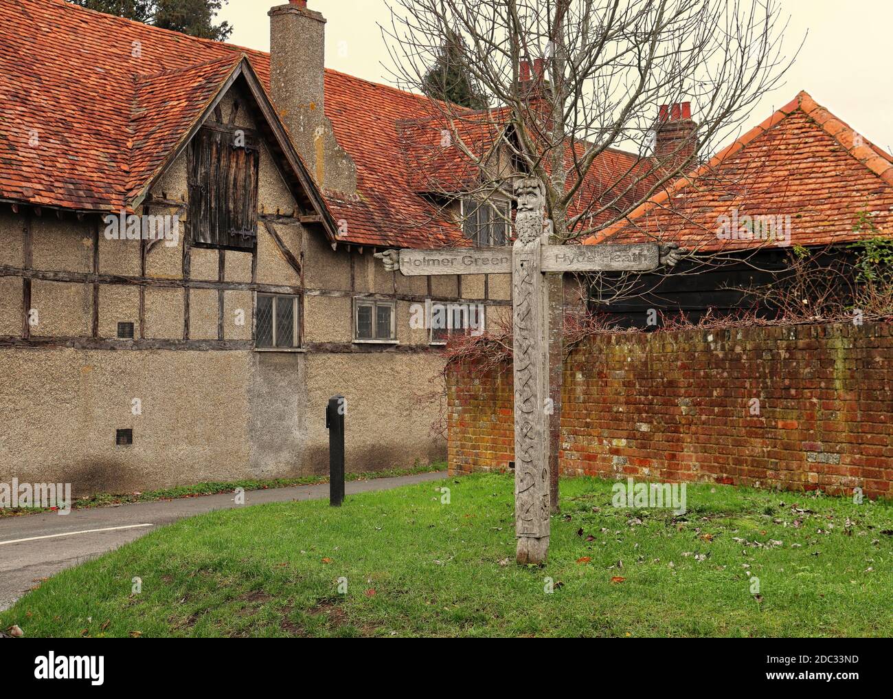 Geschnitzte hölzerne Dorf Straßenschild und Medival Herrenhaus Stockfoto