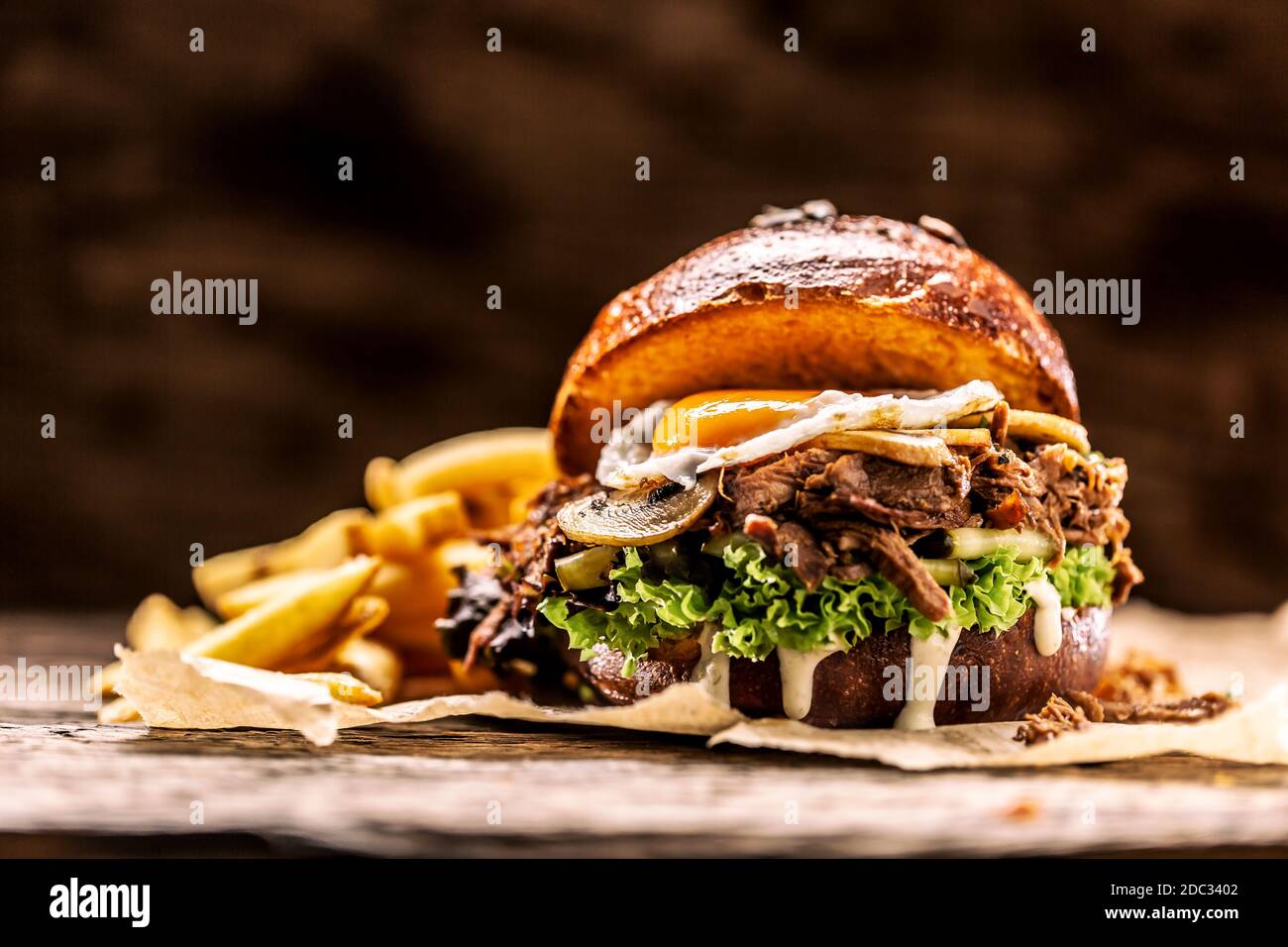 Burger gefüllt mit zerfetzten Confit puteneipilzen und französisch Pommes Stockfoto