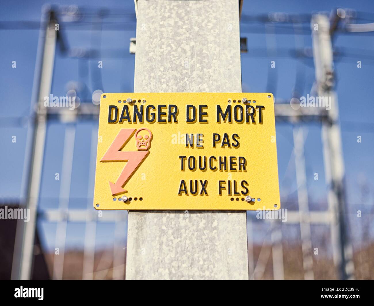 Todesgefahr. Gelbes elektrisches Warnschild in der Nähe der Eisenbahn, auf Französisch. Stockfoto