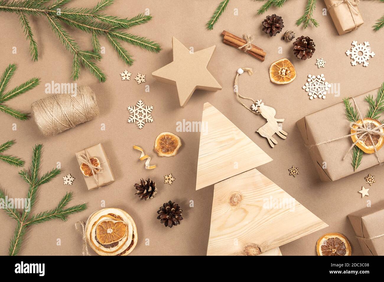 Weihnachtskomposition. Hausgemachter Weihnachtsbaum aus Holz, Geschenke, Urlaubsdekor auf hellbeigem Hintergrund, Nahaufnahme. Konzept weihnachten Null Abfall, umweltfreundlich. Stockfoto