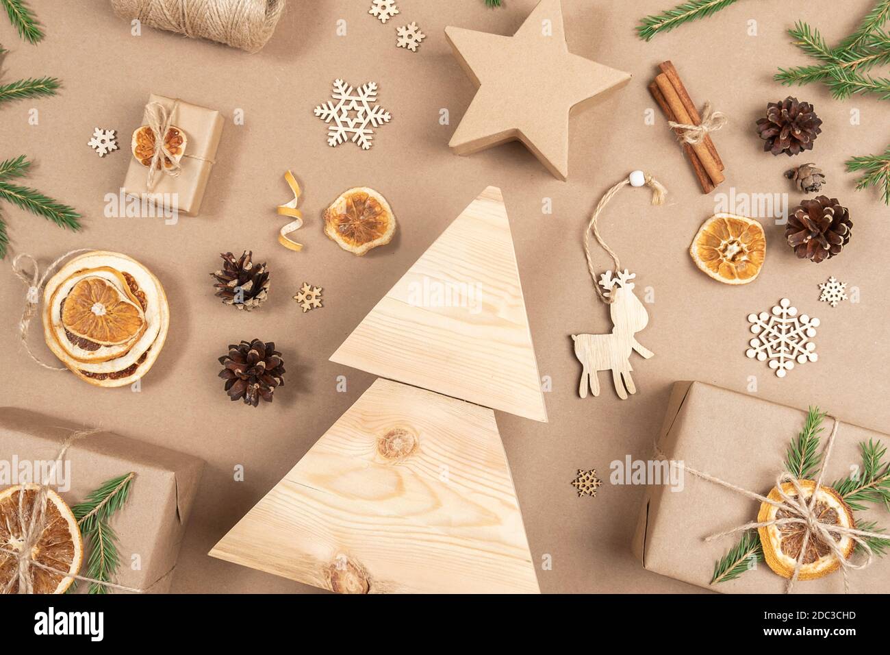 Weihnachtskomposition. Hausgemachter Weihnachtsbaum aus Holz, Geschenke, Urlaubsdekor auf hellbeigem Hintergrund, Nahaufnahme. Konzept weihnachten Null Abfall, umweltfreundlich. Stockfoto