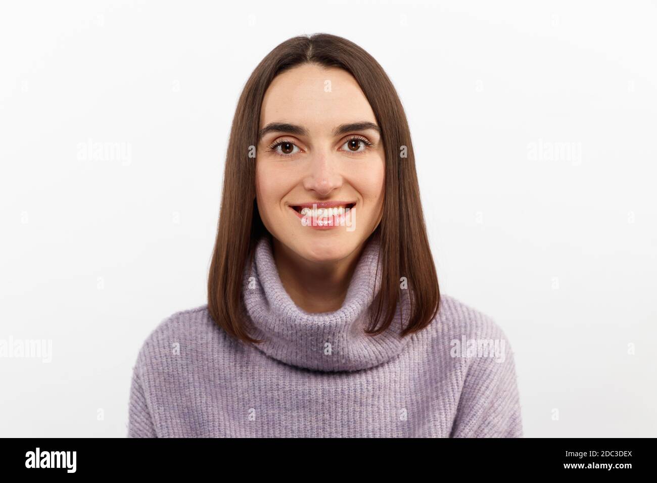 Nahaufnahme verführerisch glücklich lächelnde Brünette Frau in einem lila Pullover freuen sich auf spannende Veranstaltung, grinsend freudig Ausdruck Positivität Stockfoto