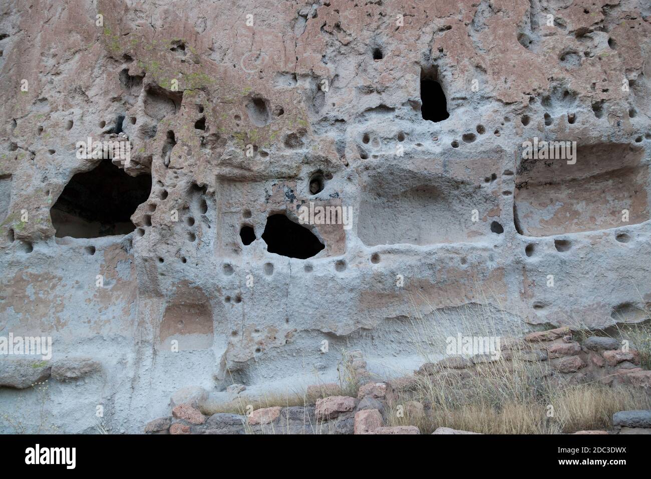Höhlenöffnungen aus Sandstein, die von den Pueblo-Leuten in New Mexico im Bandelier National Monument in eine Felswand gehauen wurden. Stockfoto