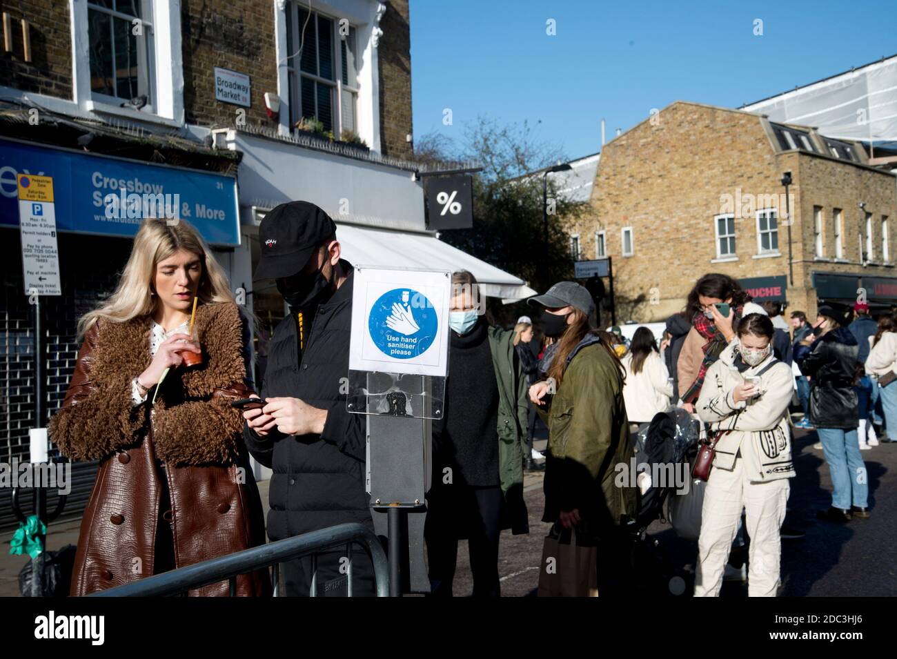 Hackney, London November 2020 während der Covid-19 (Coronavirus) Pandemie. Sperre 2. Broadway Market. Menschen mit Gesichtsmasken warten darauf, einen Bereich zu betreten Stockfoto