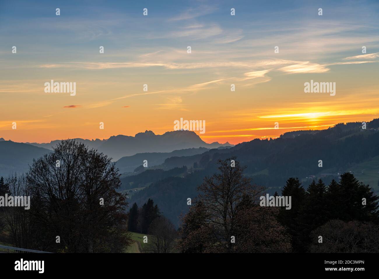 Sonnenuntergang über dem Saentis in den Schweizer Alpen mit Bregenzerwald, Österreich, Vorarlberg, im Vordergrund Stockfoto