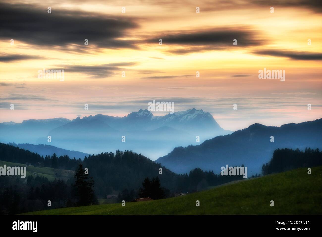Sonnenuntergang über dem Saentis in den Schweizer Alpen mit Bregenzerwald, Österreich, Vorarlberg, im Vordergrund Stockfoto