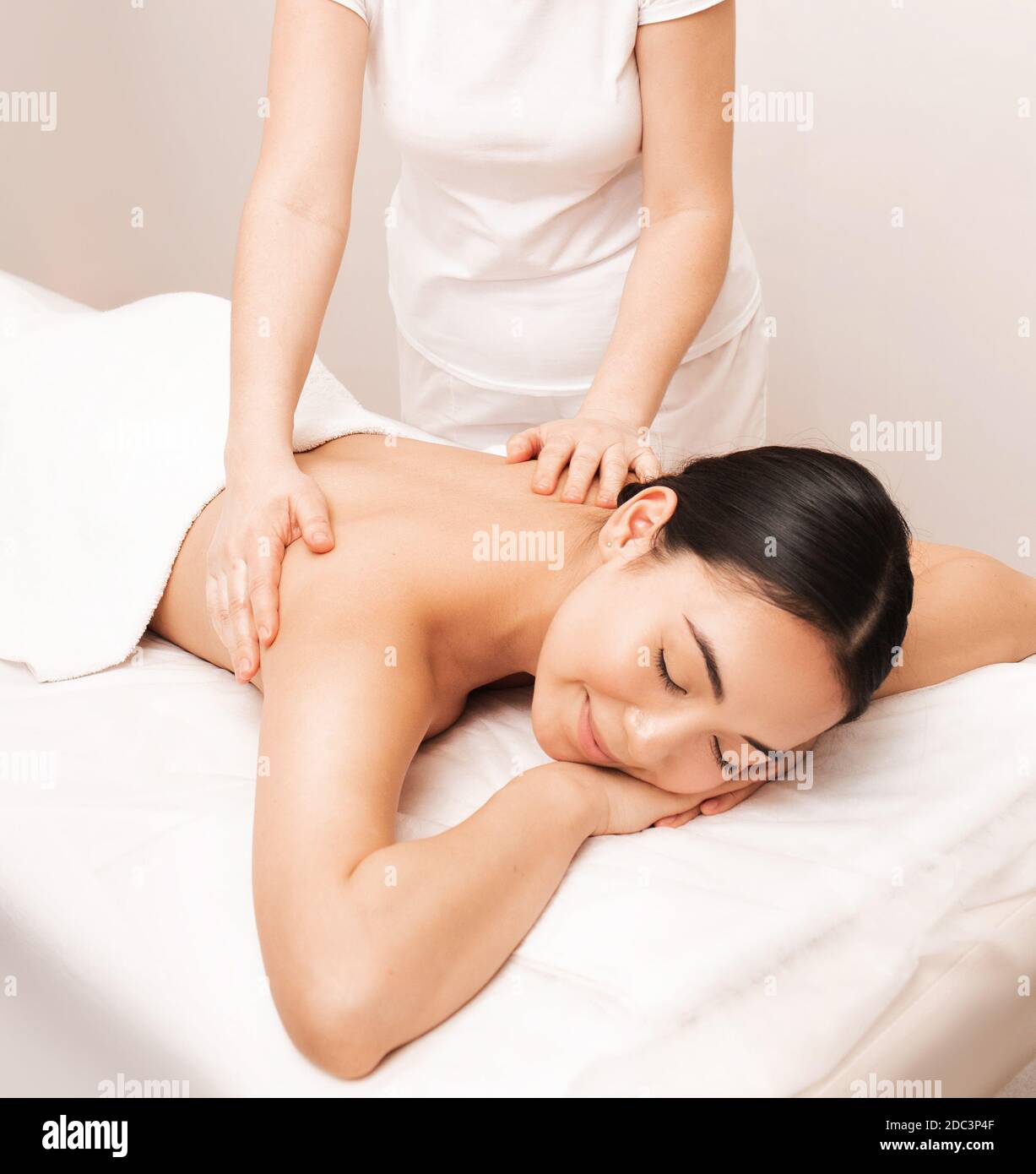 Thai-Massage. Asiatische Frau mit geschlossenen Augen in Vergnügen während der Massage im Spa-Salon Stockfoto