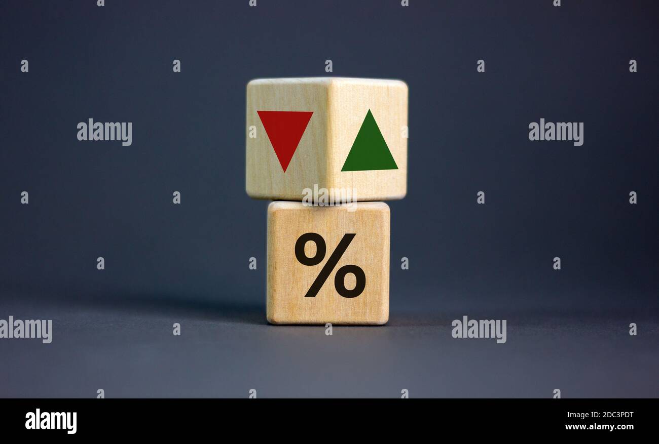Holzwürfel ändert die Richtung eines Pfeils, der symbolisiert, dass die Zinssätze sinken oder umgekehrt. Geschäftskonzept. Platz kopieren, schöner Stockfoto