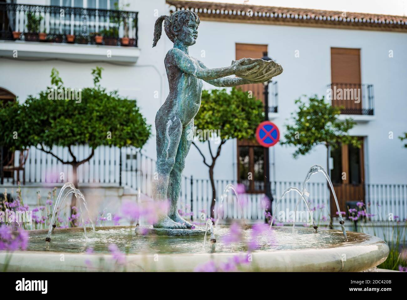 La Niña de Benalmádena, Bronzeskulptur, einzigartiges Symbol und Ikone der Stadt Benalmádena, ist Teil des Brunnens, der auf der Plaza de Espa steigt Stockfoto