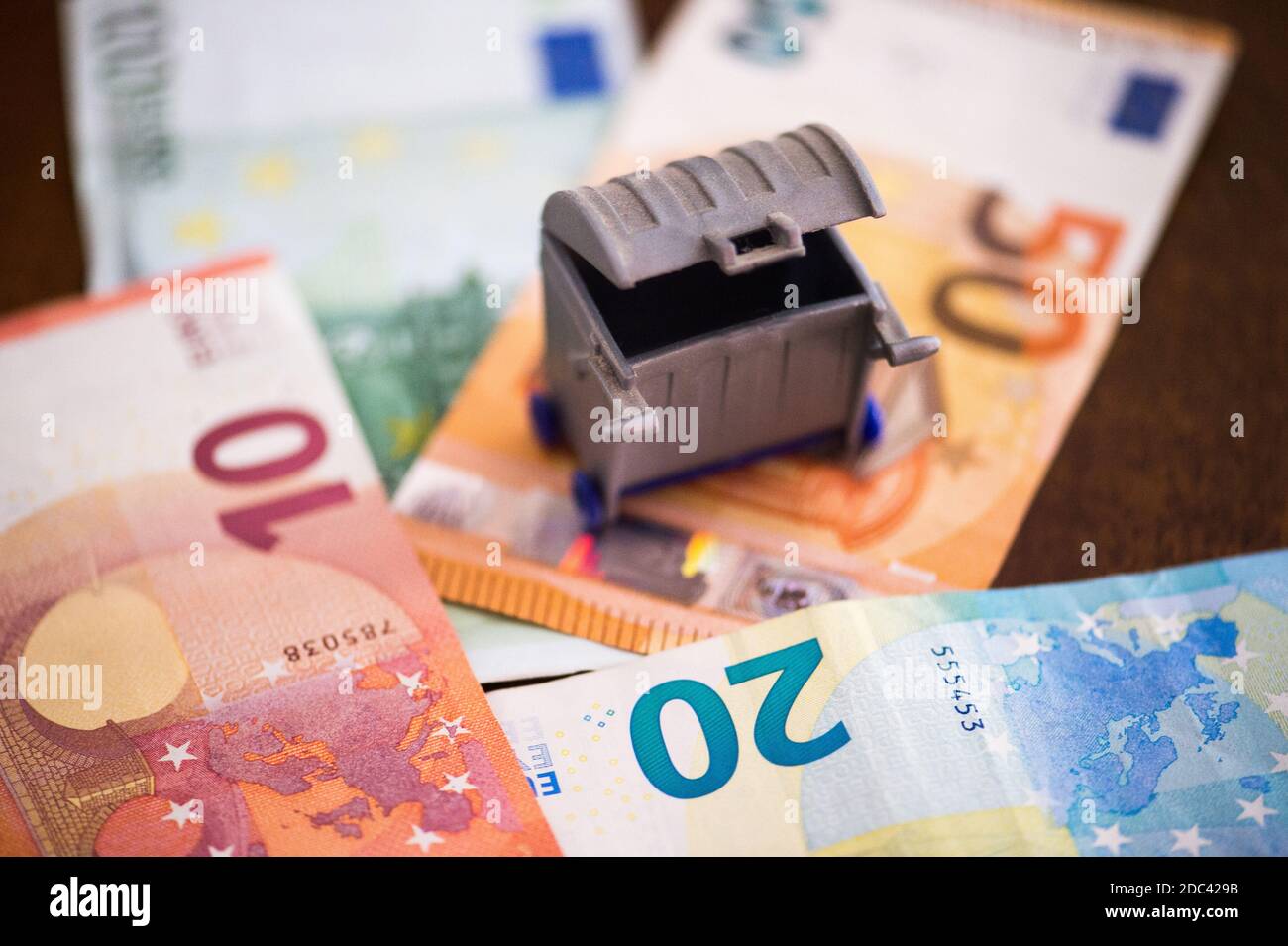 Kreatives Foto für Müllsteuer, Euro mit Müll Stockfoto