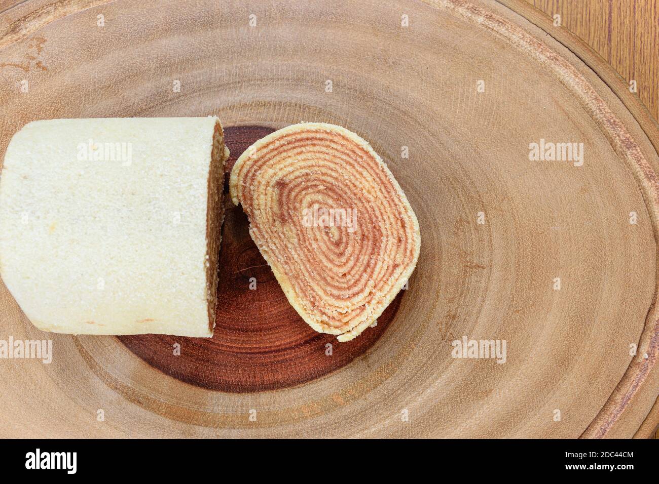 Ein Stück bolo de rolo (Kuchen Rollen) auf einem Holzbrett. Stockfoto