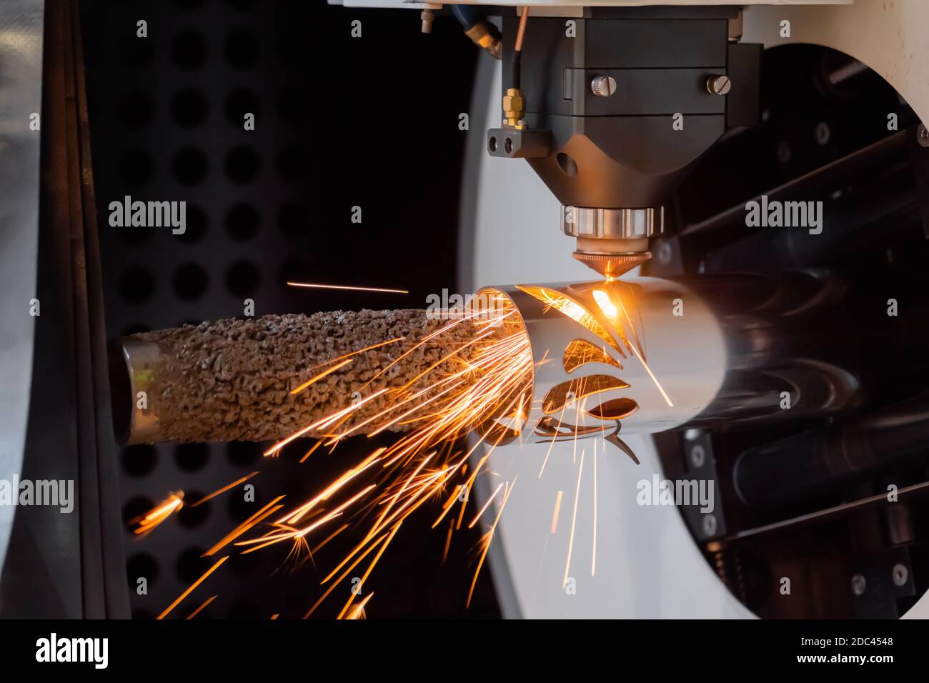 CNC-Laserschneidmaschine, die mit zylindrischem Metallwerkstück mit arbeitet Funken Stockfoto