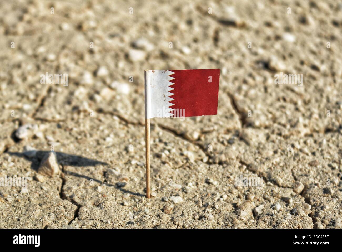 Ein Blick auf Katar Nationalflagge auf einem Wüstenland. Stockfoto