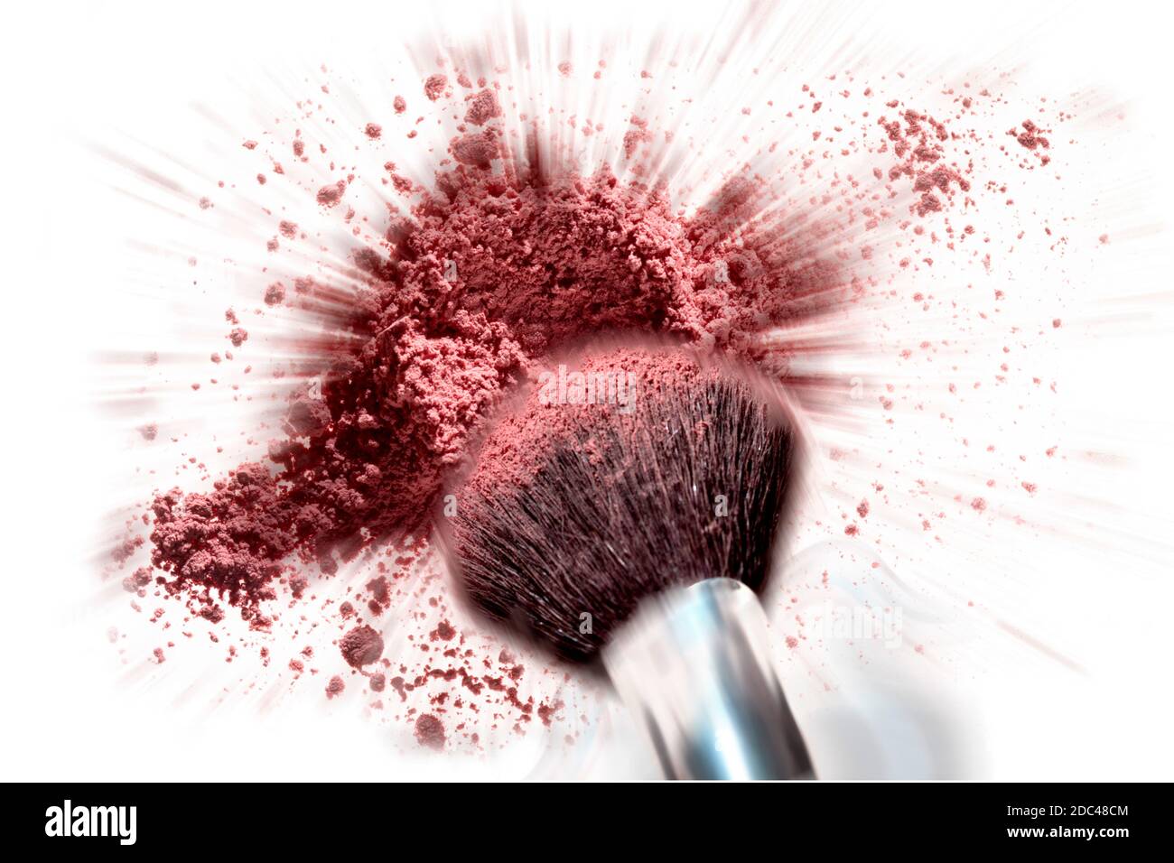 Kosmetische Bürste taucht in explodierenden Haufen von Rouge Pulver. Die Bewegung wird in diesem horizontalen Farbstudio aufgenommen. Stockfoto