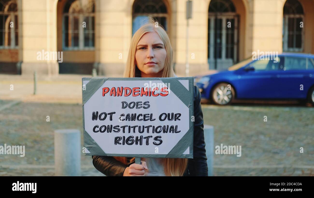 Protestmarsch erklärt, dass Pandemie die Menschenrechte nicht annulliert. Frau mit Dampfer auf der Straße. Stockfoto