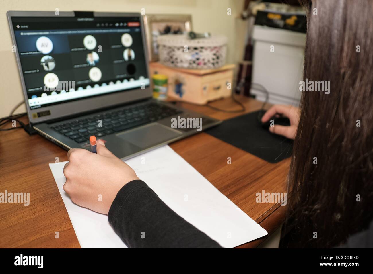 Linkshänder Mädchen, während dabei intelligente Schule Lektion Video-Anruf Auf einem Laptop, covid-19 Pandemie-Krankheit, soziale Isolation Stockfoto
