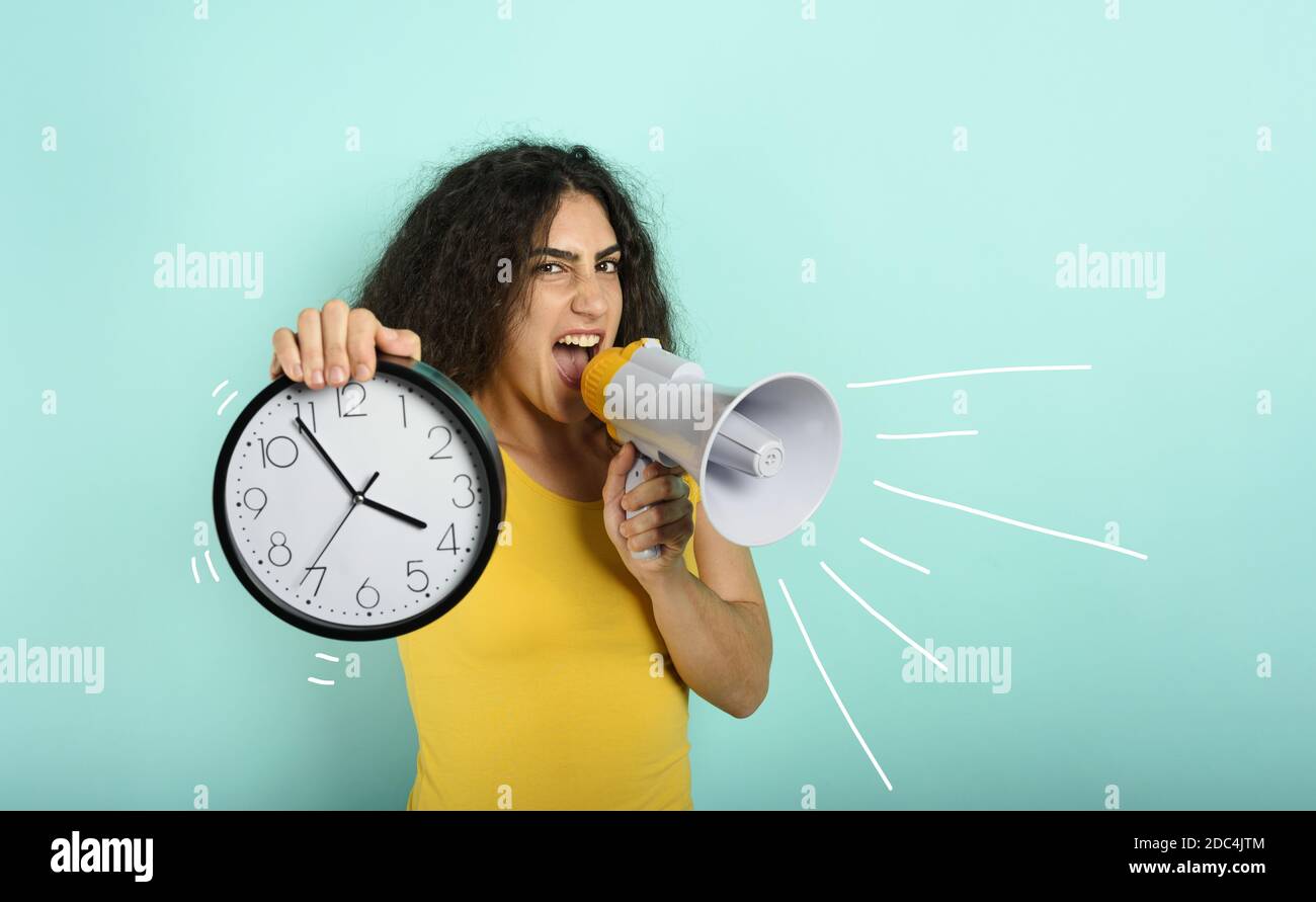 Frau schreit mit Lautsprecher, weil es zu spät ist. Wütend Ausdruck. Cyan Hintergrund Stockfoto