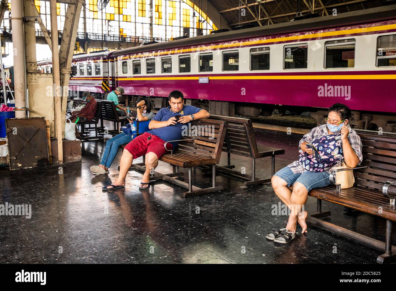 Reisende sitzen im Bahnhof Hau Lamphong in Bangkok und warten darauf, dass ihr Zug abfährt. Stockfoto