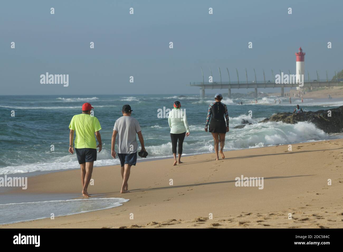 Reife Freunde Wandern am schönen Strand, Freizeit am Meer, Umhlanga Rocks Waterfront, Durban, Südafrika, Urlaubsziel, Männer, Frauen Stockfoto