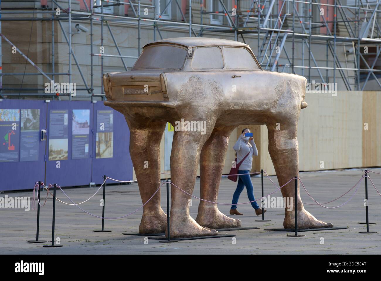 Potsdam, Deutschland. November 2020. Eine junge Frau filmt die Trabi-Skulptur auf dem Steubenplatz neben dem Landtag mit ihrem Smartphone. Das Kunstwerk "Quo Vadis" des tschechischen Künstlers David Cerny wurde kürzlich durch eine goldfarbene Kopie ersetzt. Quelle: Soeren Stache/dpa-Zentralbild/ZB/dpa/Alamy Live News Stockfoto