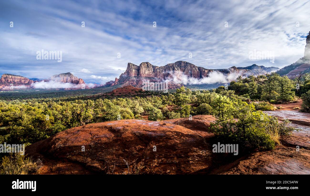 Niedrige Wolke hängt um die Red Rocks von Munds Mountain und Twin Buttes nach einem starken Regen in der Nähe der Stadt Sedona im Norden von Arizona, USA Stockfoto